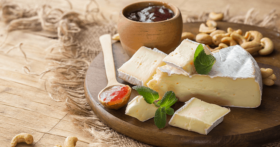 Brie cheese and jam on a circular wooden tray