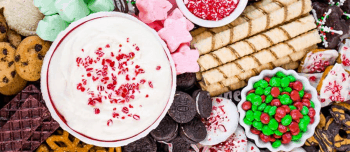 White chocolate peppermint cheesecake dip surrounded by sweet and salty snacks