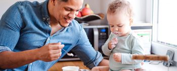 Dad feeding baby yogurt