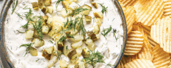 Dill Pickle Dip in a bowl surrounded by wavy potato chips