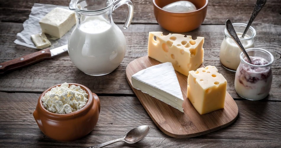 Milk, cheese and yogurt on a wooden table.